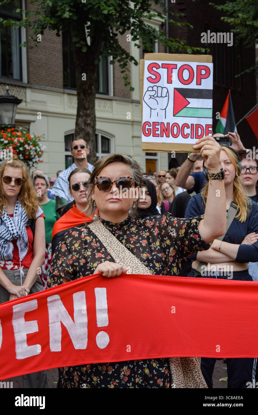 Utrecht, pays-Bas, 3 août 2025. Un manifestant tient une pancarte qui indique « Stop Genocide » pendant le rassemblement. Des centaines de personnes ont défilé à travers le centre d’Utrecht pour protester contre la famine de Gaza et pour soutenir les journalistes qui sont ciblés par Israël et tués dans l’exercice de leur métier. Crédit : Dimitris Aspiotis/Alamy Live News Banque D'Images