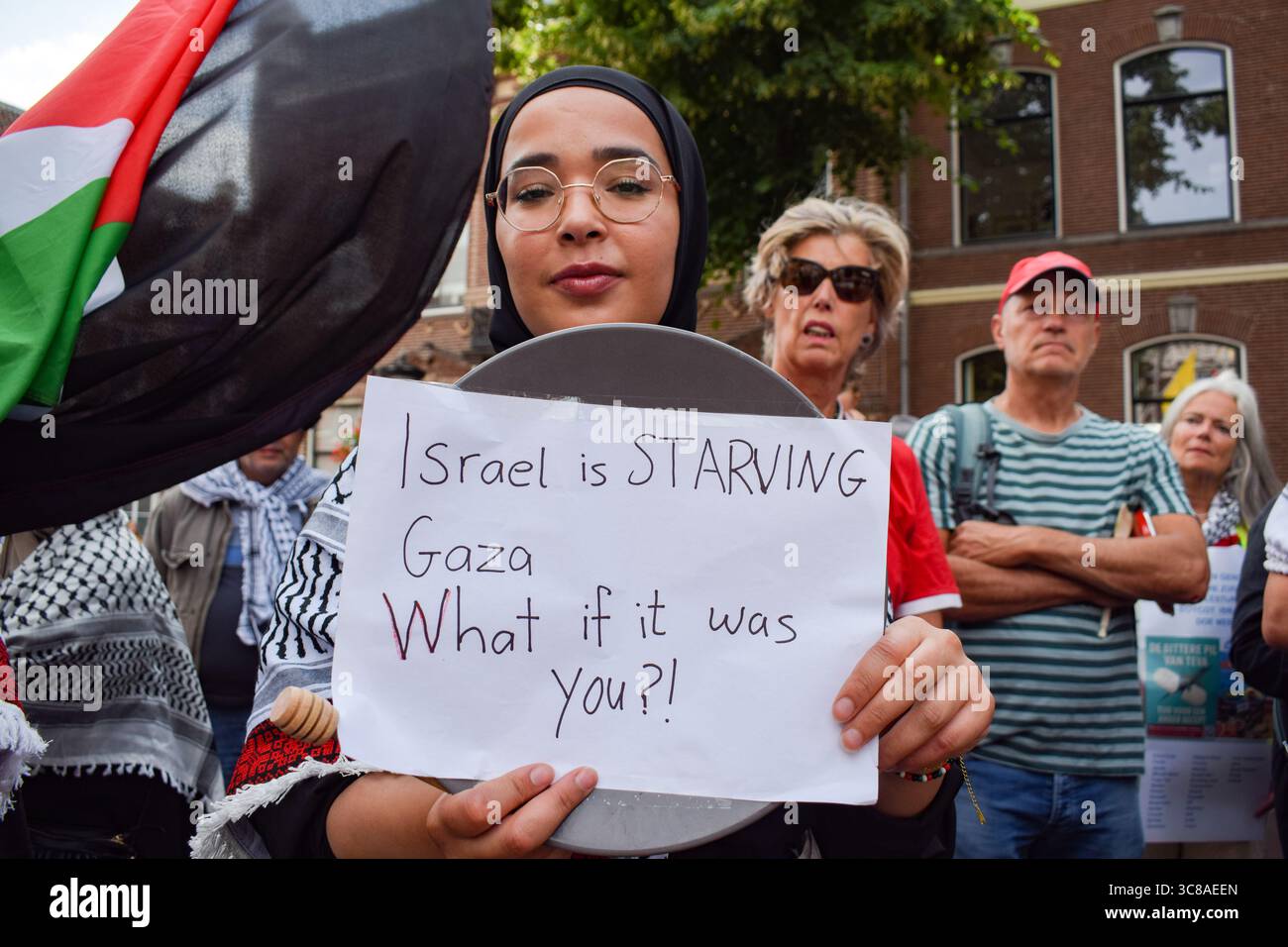 Utrecht, pays-Bas, 3 août 2025. Un manifestant tient une pancarte qui dit : « Israël affame Gaza » pendant le rassemblement. Des centaines de personnes ont défilé à travers le centre d’Utrecht pour protester contre la famine de Gaza et pour soutenir les journalistes qui sont ciblés par Israël et tués dans l’exercice de leur métier. Crédit : Dimitris Aspiotis/Alamy Live News Banque D'Images