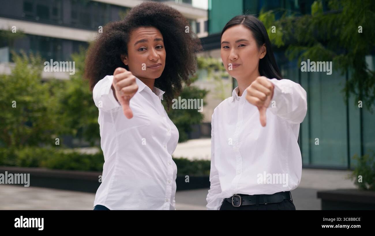 Insatisfait afro-américaine asiatique coréenne femmes d'affaires femmes montrant le pouce vers le bas rejeter refuser refuser avertir les collègues d'affaires collègues non Banque D'Images