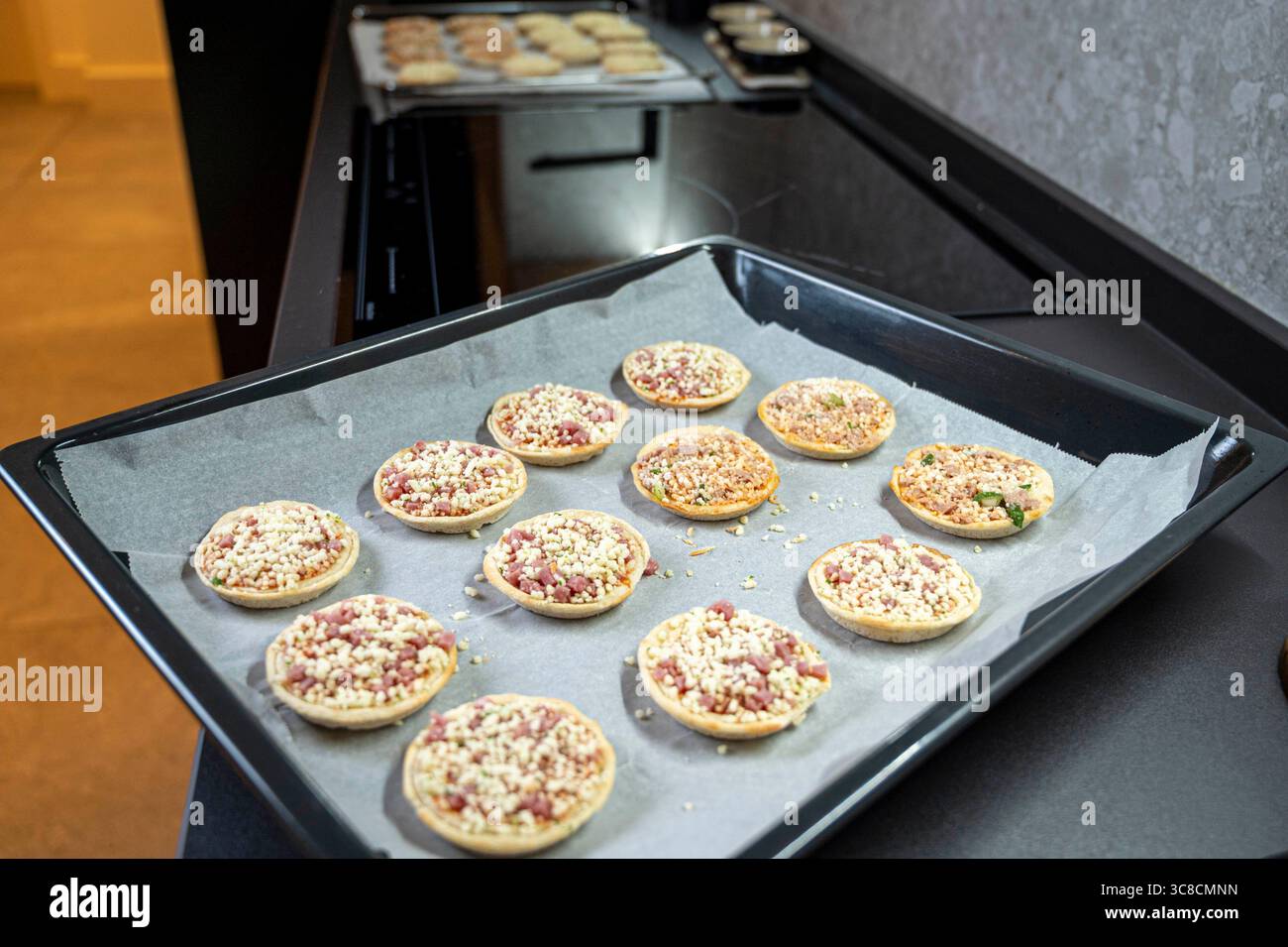 Un plateau de mini pizzas se trouve sur un comptoir. Les pizzas sont petites et ont une variété de garnitures Banque D'Images