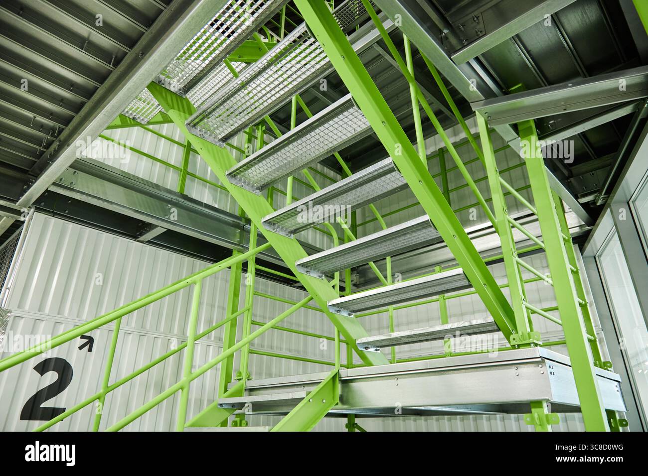 Escalier industriel moderne avec marches en métal vert dans l'intérieur de l'entrepôt Banque D'Images