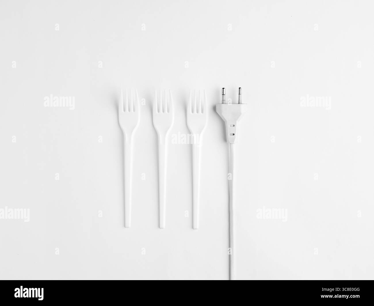 Une nature morte minimaliste avec des fourchettes en plastique blanc et une prise électrique sur fond blanc, symbolisant la consommation alimentaire moderne, livi artificiel Banque D'Images