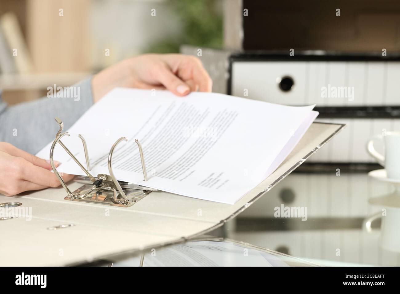 Gros plan portrait d'une main de femme organisant le document dans le classeur à anneaux Banque D'Images