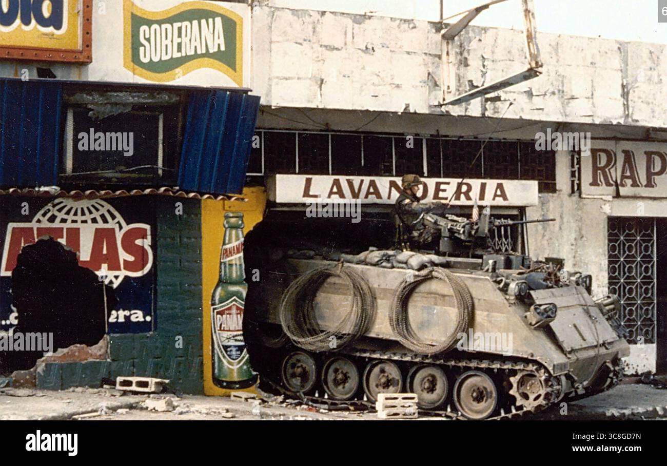 INVASION AMÉRICAINE DU PANAMA DÉCEMBRE 1989. Un véhicule blindé de transport de troupes américain M113 prend garde à l'extérieur d'une blanchisserie pendant le deuxième jour de l'opération Just cause. Banque D'Images
