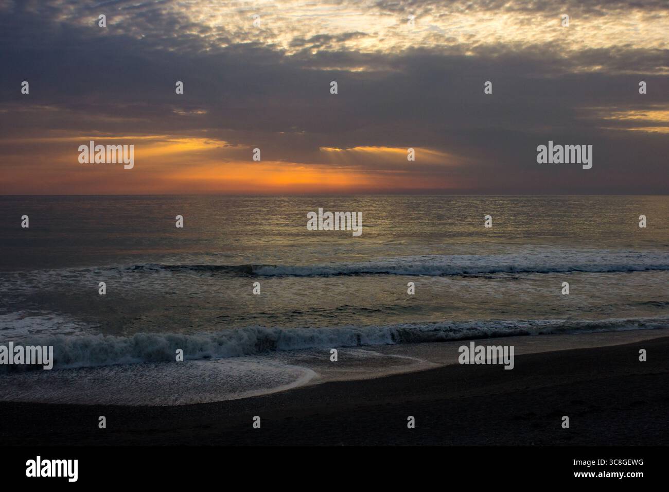 Coucher de soleil sur la mer d'Irlande, vu de la plage de galets à Aberystwyth au pays de Galles. Banque D'Images