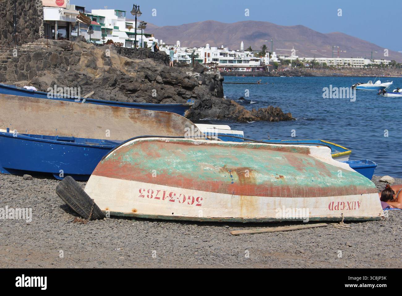 Bateaux de pêche dans le port de Playa Blanca, Lanzarote, îles Canaries, avec ciel bleu et mer en arrière-plan Banque D'Images
