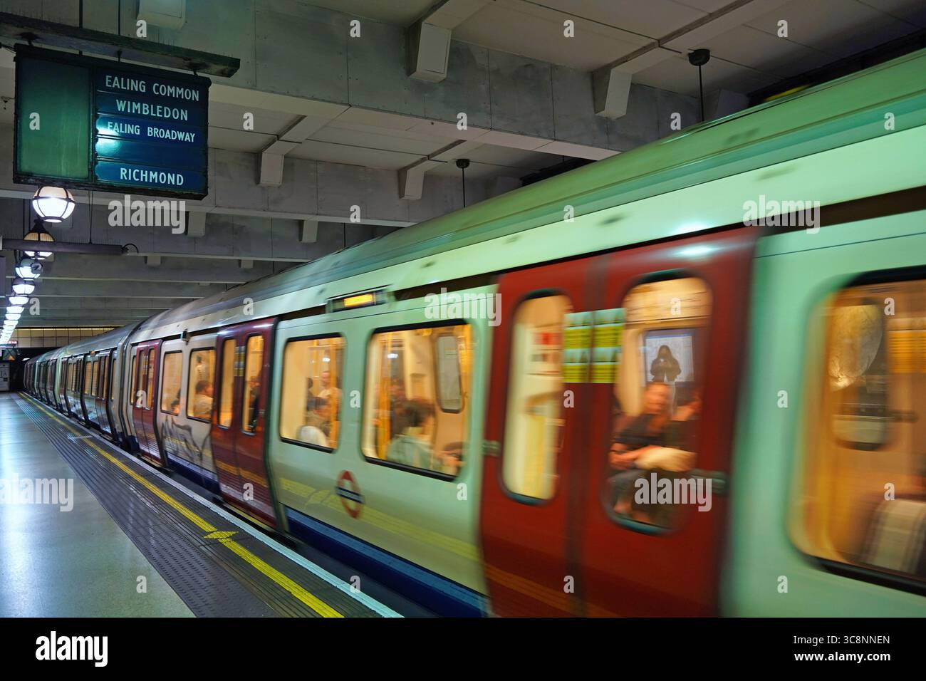 Le métro londonien accélère à la sortie d'une gare Banque D'Images