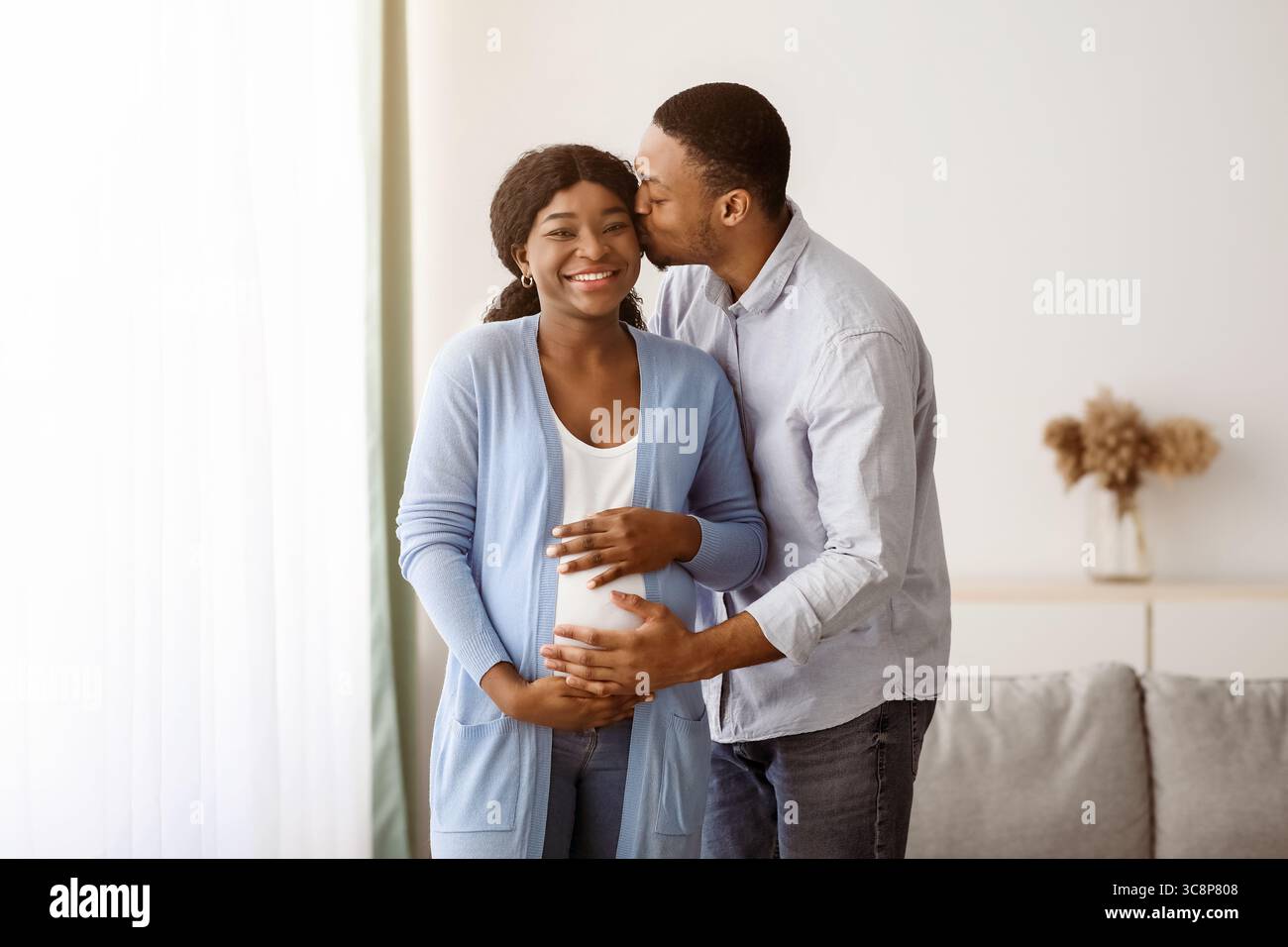Homme noir aimant embrassant sa femme enceinte Banque D'Images