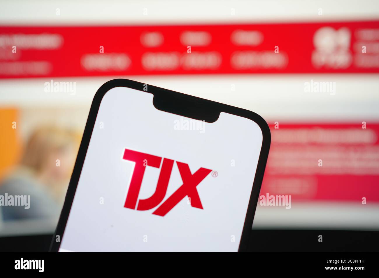Roosendaal, pays-Bas - 04 août 2025 : un téléphone portable affichant le logo de la société TJX, avec le site Web de la société en arrière-plan. Banque D'Images