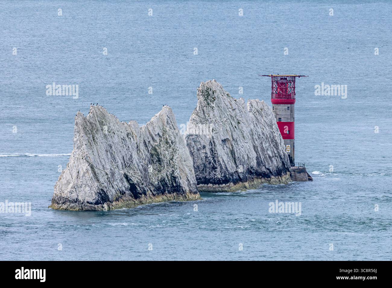Une vue sur les rochers Needles et le phare, avec la mer calme environnante Banque D'Images