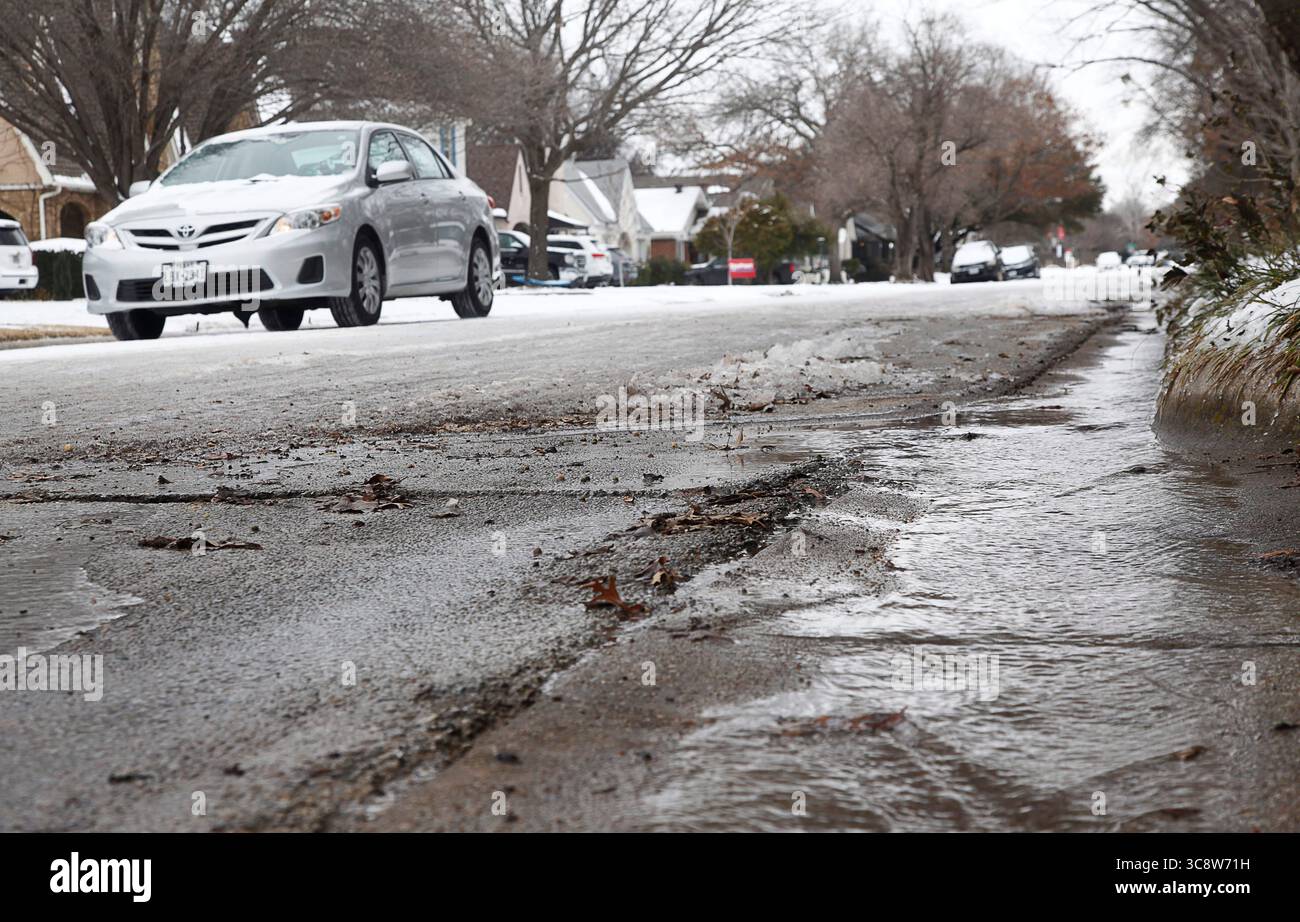 18 février 2021, FORT WORTH, TEXAS, ÉTATS-UNIS : jeudi, 18 février 2021. Un torrent d'eau coule le long d'une rue de la ville en raison d'une rupture de conduite d'eau à cause du gel après des jours de températures glaciales. Couverture de glace, neige et temps froid North Texas à nouveau avec un temps anormalement glacial et des températures ne dépassant pas le point de congélation pour la cinquième journée consécutive à Fort Worth, Texas, États-Unis. (Crédit image : © Ralph LauerZUMA Wire) Banque D'Images