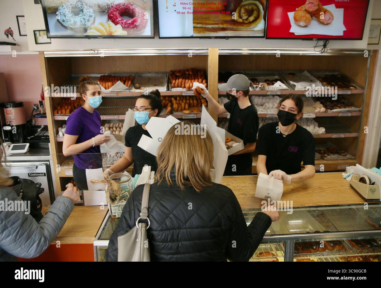 22 février 2021, États-Unis : les ouvriers de Spunky Dunkers de gauche, Maggie O'Brien, Michelle Hanrahan, Brenday Rolloff et Ilianna Giannakouras s'acharnent à remplir les commandes de beignets chez Spunky Dunkers le 21 février 2021, au Palatin. Des gens de partout dans la région ont fait la queue à l'extérieur pour montrer leur soutien à l'entreprise en difficulté. (Crédit image : © TNS via ZUMA Wire) Banque D'Images