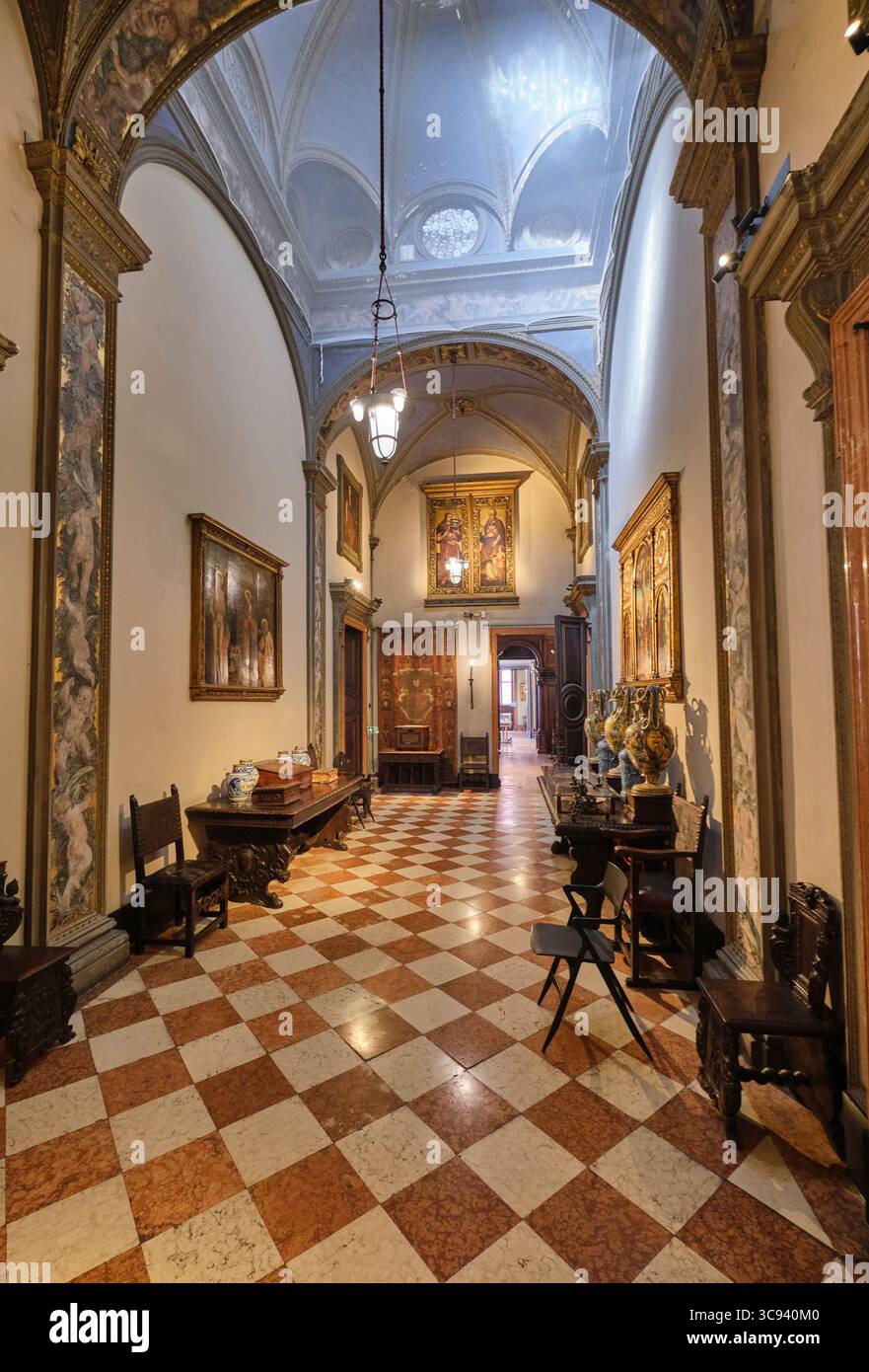 Un couloir avec carreaux en damier, sol en marbre et peintures religieuses sur les murs. Au musée Bagatti Valsecchi à Milan, Italie. Banque D'Images