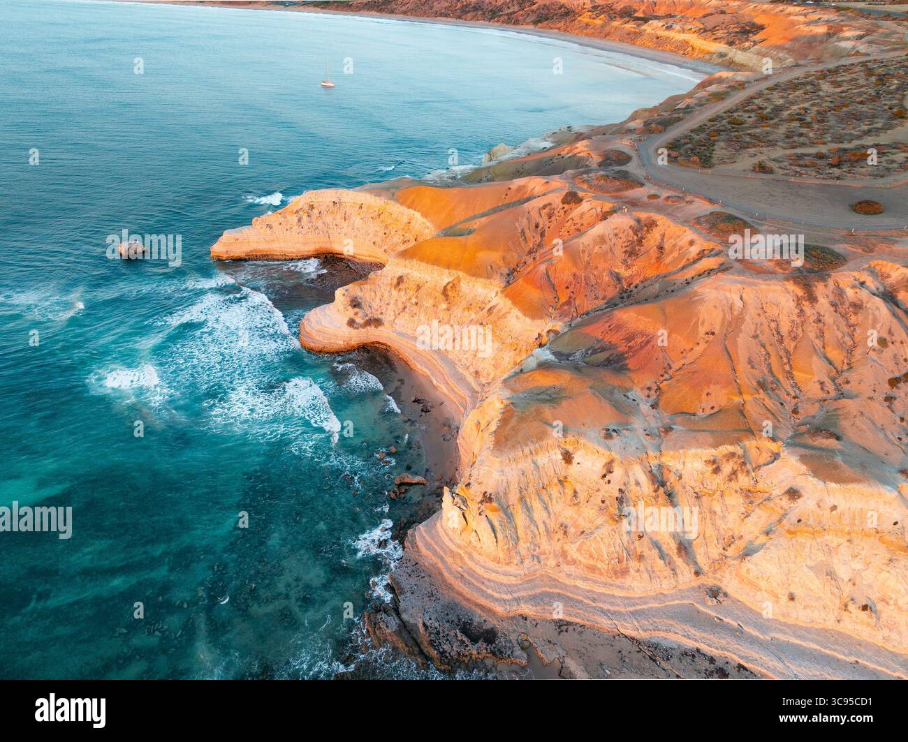 Vue aérienne d'un belvédère au-dessus de falaises côtières accidentées sous un soleil doré à Maslin Beach sur la péninsule de Fluerieu en Australie méridionale Banque D'Images