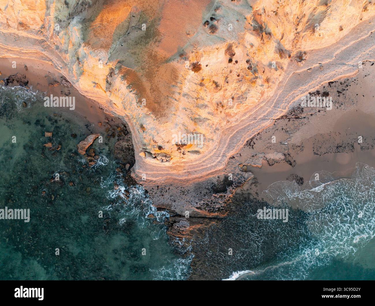 Vue aérienne d'une côte érodée au-dessus d'une côte arocky dans la lumière dorée à Maslin Beach sur la péninsule de Fluerieu en Australie méridionale Banque D'Images