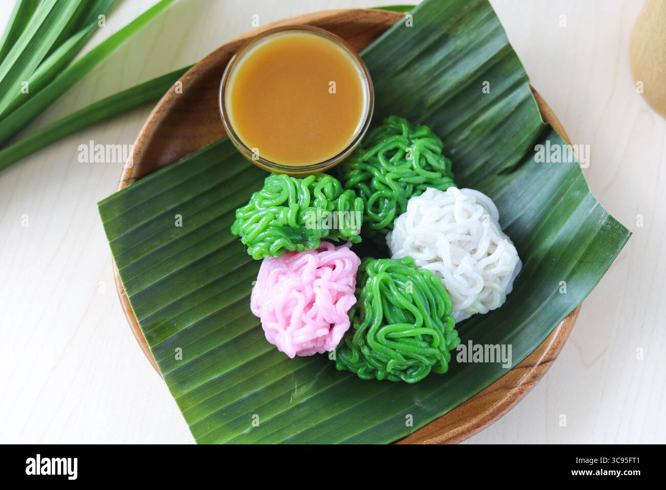 Kue Putu Mayang, un gâteau traditionnel indonésien cuit à la vapeur, présente des brins uniques ressemblant à des nouilles à base de farine de riz et de sauce au sucre de palme (kinca). Banque D'Images