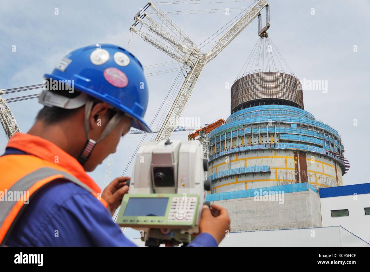 YANTAI, CHINE - 4 AOÛT 2025 - Un membre du personnel surveille le processus de levage du module CB20 sur le site de levage de l'île nucléaire de l'unité 3 de la centrale nucléaire de Shandong Haiyang. Centrale nucléaire de Shandong Haiyang à Yantai, Shandong, Chine, le 4 août 2025. Banque D'Images