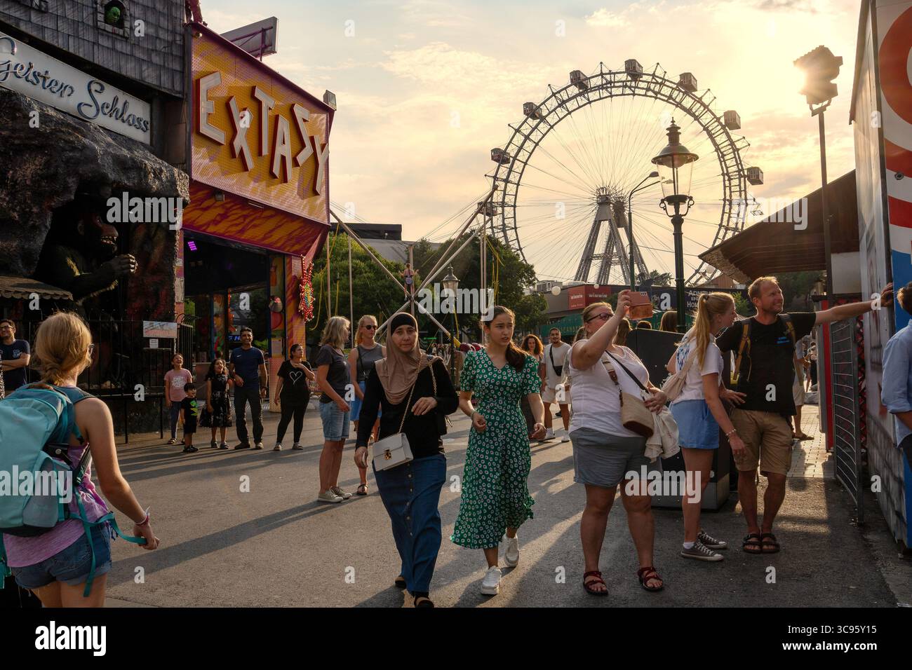 VIENNE, AUTRICHE - 14 AOÛT 2024 : une foule diversifiée de touristes et d'habitants se promène dans le parc d'attractions Prater par une soirée d'été ensoleillée, avec le Banque D'Images