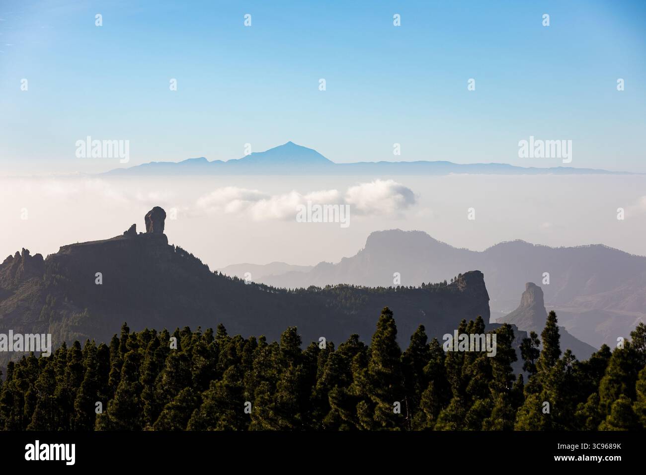 Vue du monolithe volcanique Roque Nublo debout garde au-dessus d'une mer de nuages, avec le pic de Tenerife perçant l'horizon, Pico de las Nieves, Gran CA Banque D'Images