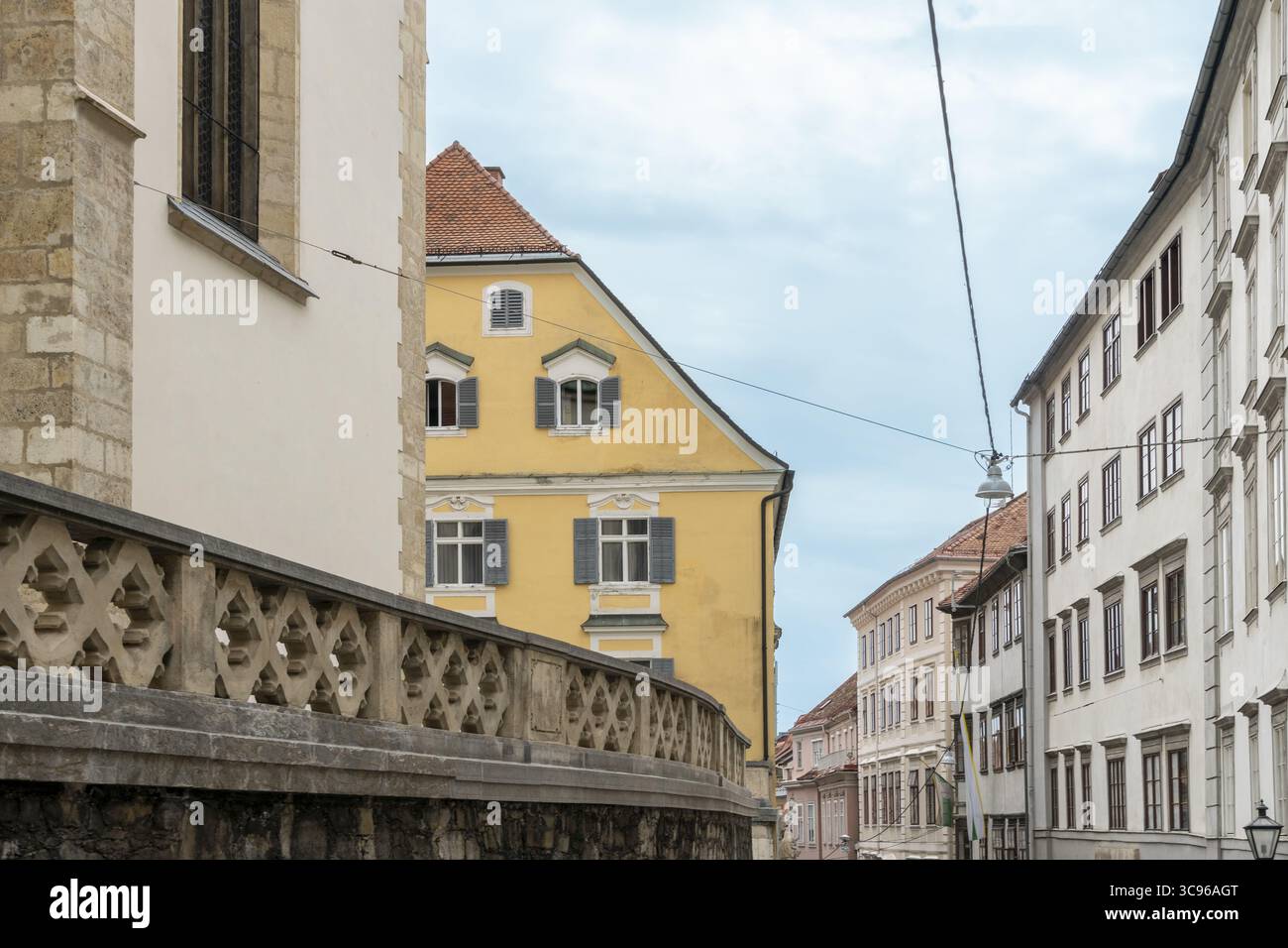 Vue sur les façades ensoleillées et les toits en terre cuite contrastent avec le ciel, tandis que les bâtiments historiques bordent les rues, un mélange de charme du vieux monde, Graz, Styrie, Autriche. Banque D'Images