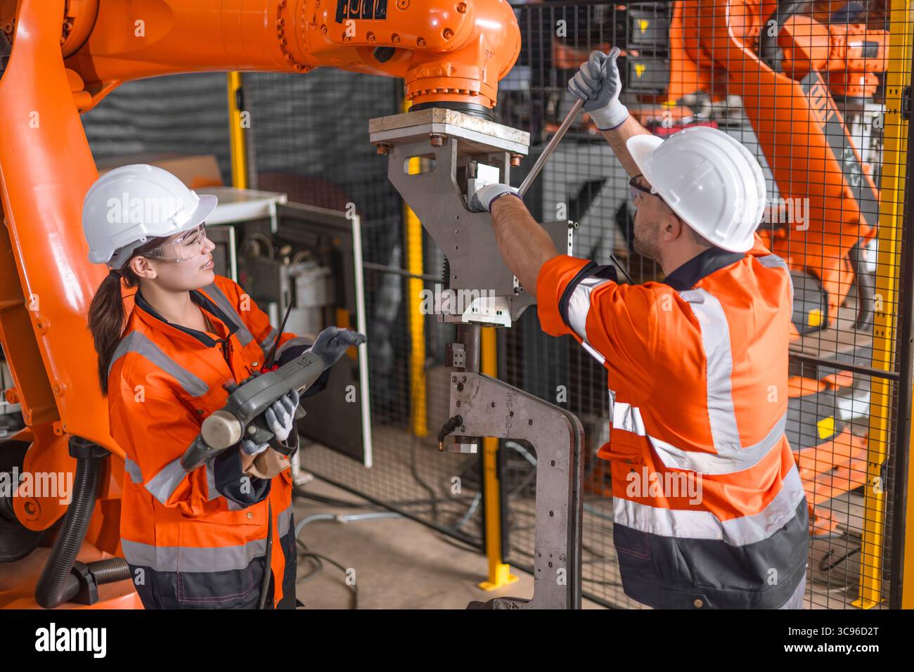 l'équipe d'ingénieur technicien fixe l'installation automatique de machine de bras de robot d'inspection de maintenance de service dans l'usine moderne. les ouvriers vérifient la réparation de réglage Banque D'Images