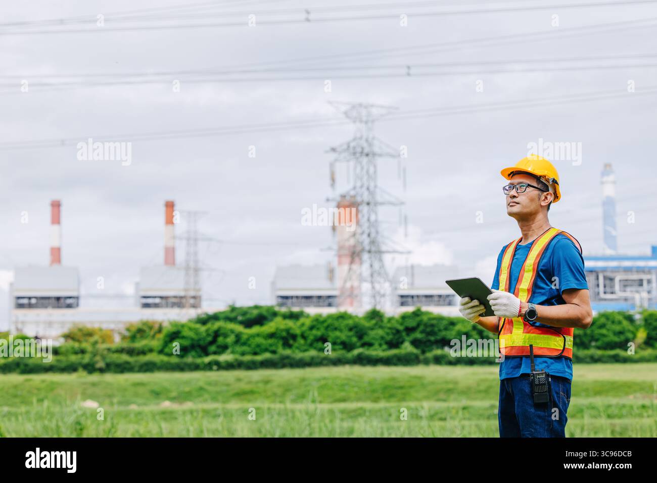 Ingénieur professionnel travailleur masculin avec centrale à charbon, centrale électrique avec fond vert de nature Banque D'Images