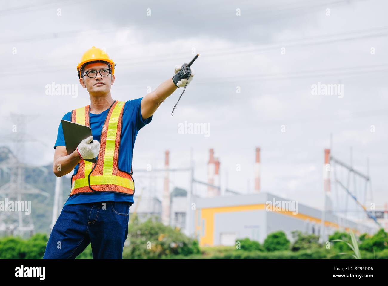 Ingénieur professionnel travailleur masculin avec centrale à charbon, centrale électrique avec fond vert de nature Banque D'Images