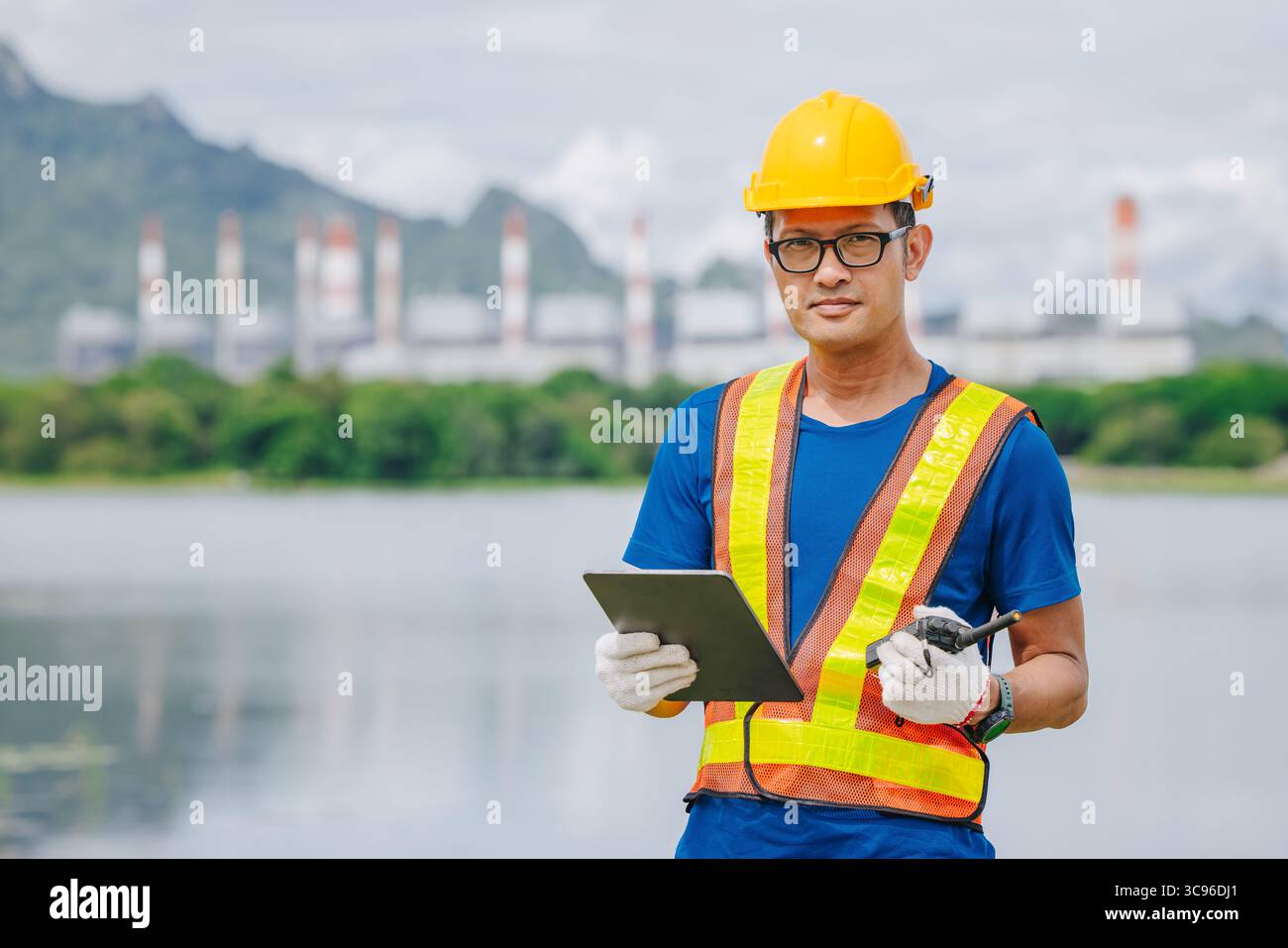 Ingénieur professionnel travailleur masculin avec centrale à charbon, centrale électrique avec fond vert de nature Banque D'Images