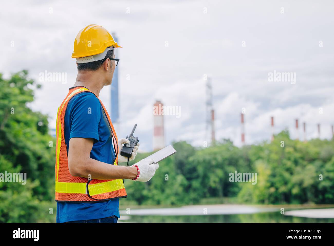 Ingénieur professionnel travailleur masculin avec centrale à charbon, centrale électrique avec fond vert de nature Banque D'Images