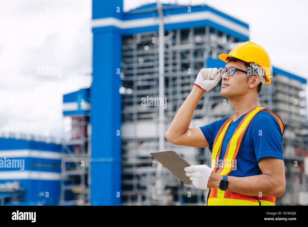 Ingénieur professionnel travailleur masculin avec centrale à charbon, centrale électrique avec fond vert de nature Banque D'Images