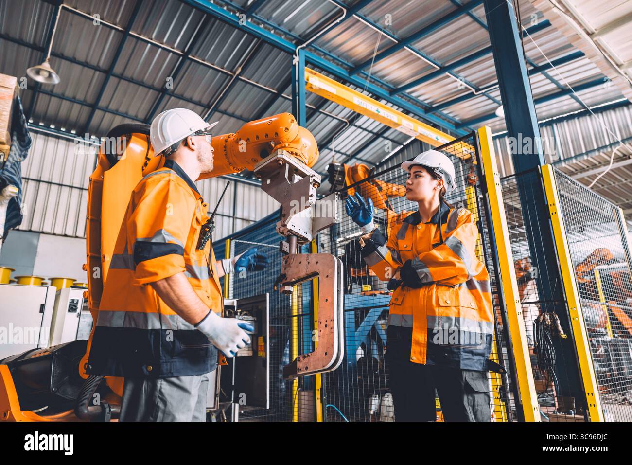 Service d'équipe d'ingénieur soudage de robot travaillant dans l'usine d'automatisation. Machine de robot de contrôle de travail de sécurité des travailleurs de personnes dans la technologie de l'industrie lourde. Banque D'Images