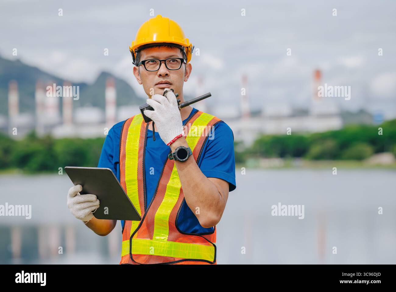 Ingénieur professionnel travailleur masculin avec centrale à charbon, centrale électrique avec fond vert de nature Banque D'Images