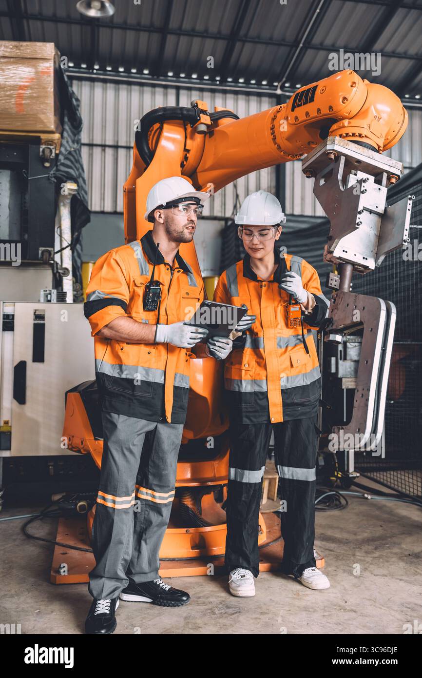 Service d'équipe d'ingénieur soudage de robot travaillant dans l'usine d'automatisation. Machine de robot de contrôle de travail de sécurité des travailleurs de personnes dans la technologie de l'industrie lourde. Banque D'Images