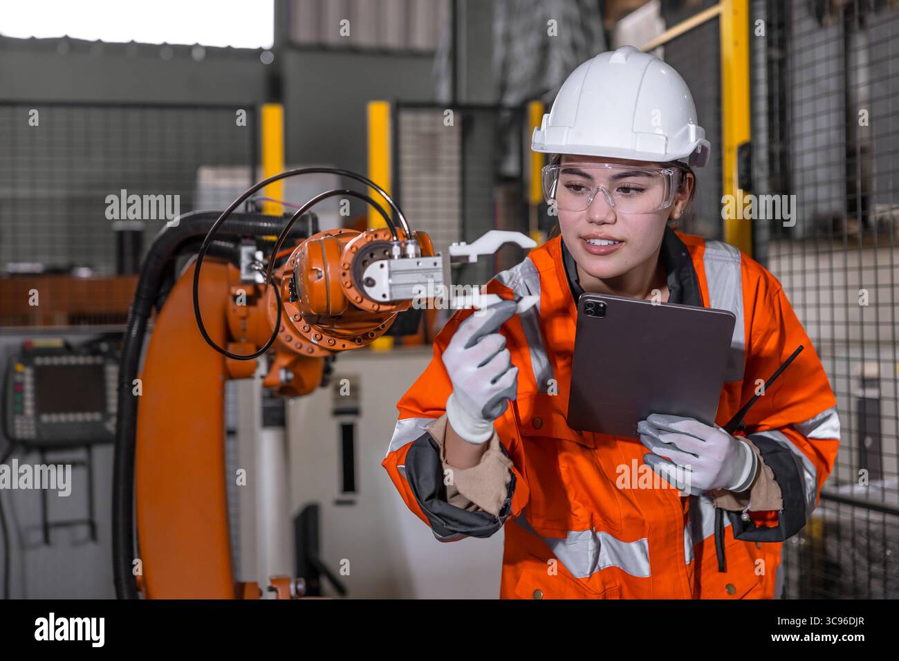 Les femmes ingénieurs techniciens testent le contrôle d'inspection de l'installation de bras de robot en usine. robot de réglage de contrôle de travailleur avec tablette. Banque D'Images