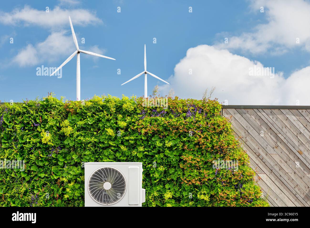 Pompe à chaleur à source d'air sur un bâtiment durable vert avec des centrales verticales et des éoliennes Banque D'Images