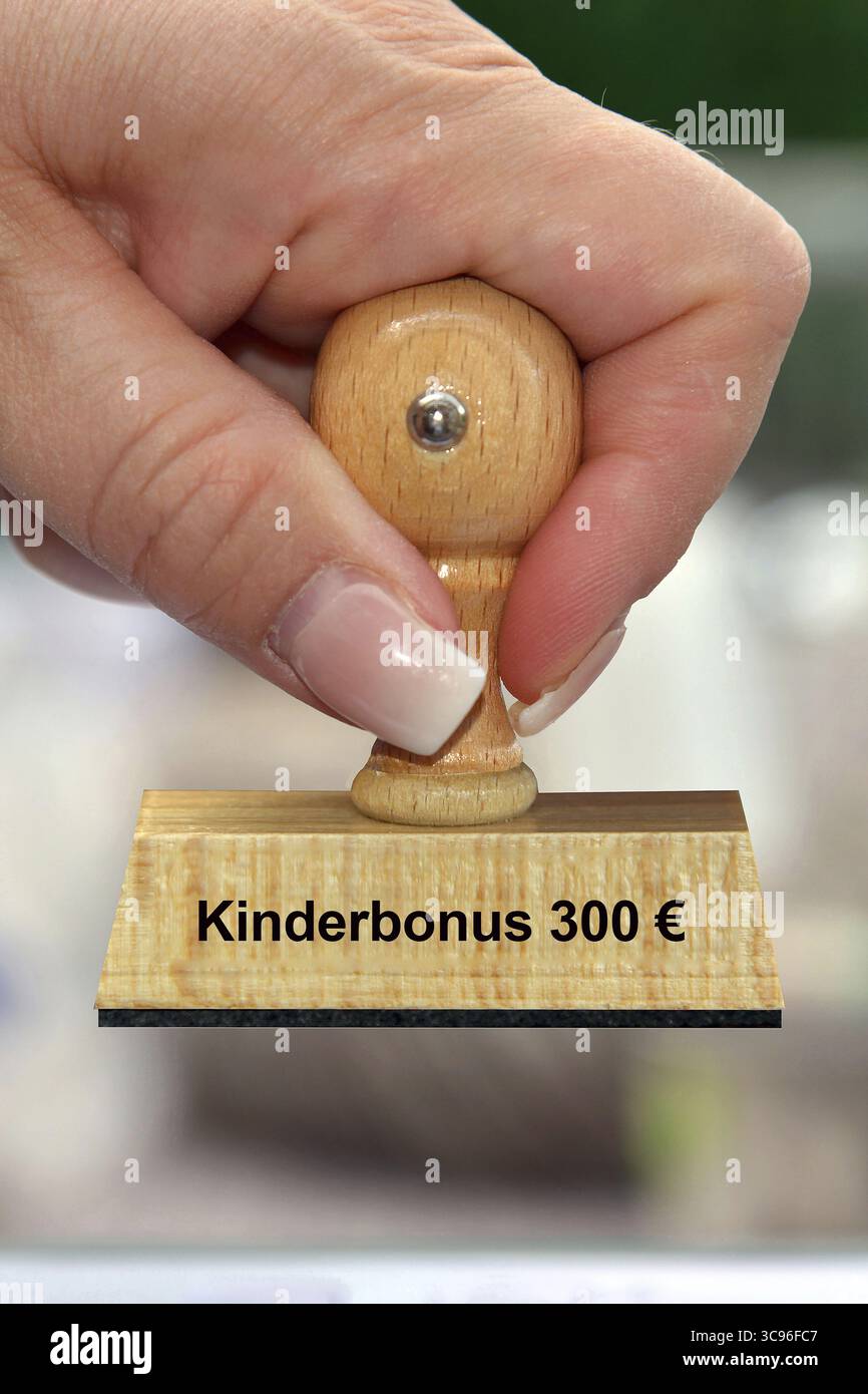 Photo symbolique, main de femme avec timbre, inscription : Kinderbonus 300 euro, Studio, basse-Saxe, République fédérale d'Allemagne Banque D'Images