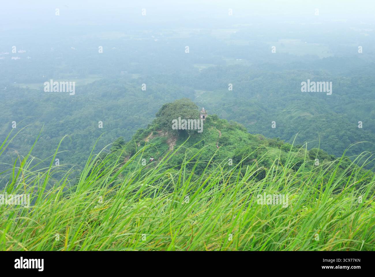 Sitakund, Bangladesh - 04 mars 2019 : vue sur le temple de Chandranath niché au sommet d'une colline verdoyante et luxuriante, embrassée par une mer d'arbres vert émeraude et de végétation. Banque D'Images