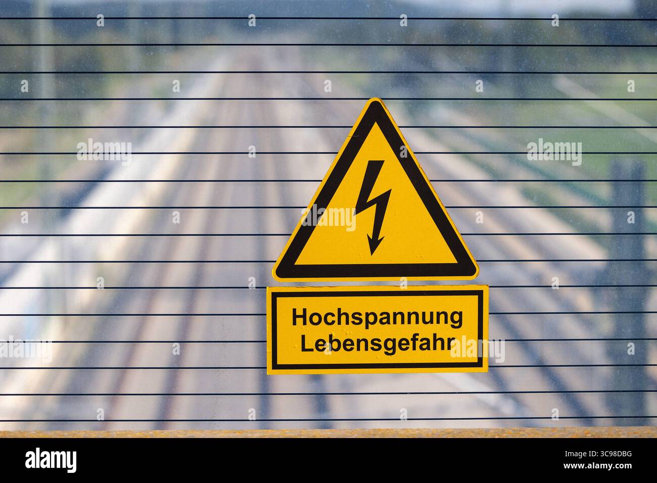 Ausbau der Schnellfahrstrecke Nürnberg Berlin im Rahmen des Verkehrsprojekts Deutsche Einheit Nr. 8, Eggolsheim, 04.08.2025 Warnschild mit dem Hinweis Hochspannung Lebensgefahr an einer durchsichtigen Schutzwand mit Blick auf eine mehrgleisige Bahnstrecke. DAS Schild warnt vor der lebensgefährlichen Gefahr eines Stromschlags im Bereich elektrifizierter Bahntrassen. Hintergrund ist das Risiko, insbesondere für Jugendliche, durch das Klettern auf Züge oder in den Bereich von Oberleitungen mit hoher Spannung zu geraten. Eggolsheim Bayern Deutschland *** expansion de la haute vitesse Nuremberg-Berlin Banque D'Images Ausbau der Schnellfahrstrecke Nürnberg Berlin im Rahmen des Verkehrsprojekts Deutsche Einheit Nr. 8, Eggolsheim, 04.08.2025 Warnschild mit dem Hinweis Hochspannung Lebensgefahr an einer durchsichtigen Schutzwand mit Blick auf eine mehrgleisige Bahnstrecke. DAS Schild warnt vor der lebensgefährlichen Gefahr eines Stromschlags im Bereich elektrifizierter Bahntrassen. Hintergrund ist das Risiko, insbesondere für Jugendliche, durch das Klettern auf Züge oder in den Bereich von Oberleitungen mit hoher Spannung zu geraten. Eggolsheim Bayern Deutschland *** expansion de la haute vitesse Nuremberg-Berlin Banque D'Images
