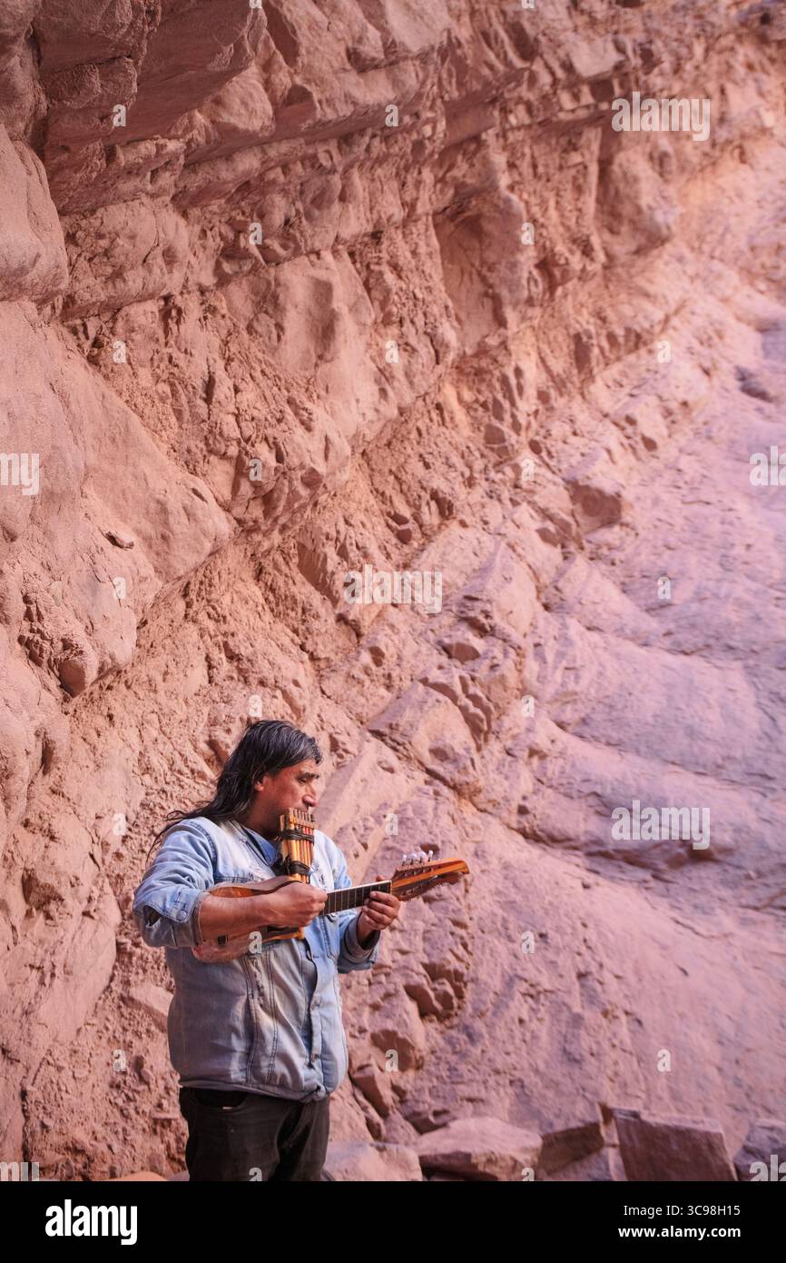 Musicien local jouant du charango et de la flûte pan à l'intérieur de l'amphithéâtre de la Quebrada de las Conchas à Salta, au nord-ouest de l'Argentine. Banque D'Images