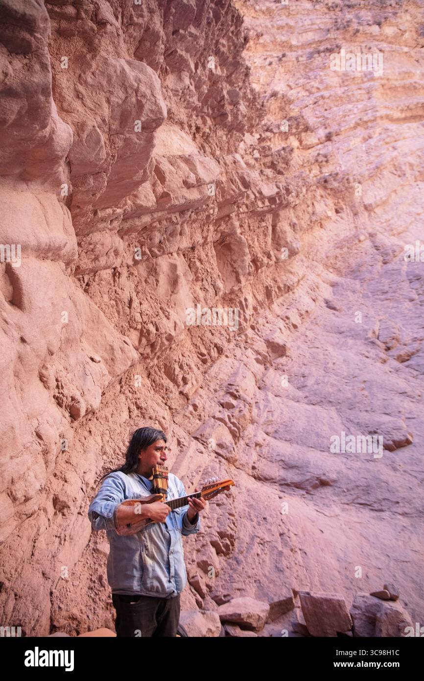 Musicien local jouant du charango et de la flûte pan à l'intérieur de l'amphithéâtre de la Quebrada de las Conchas à Salta, au nord-ouest de l'Argentine. Banque D'Images