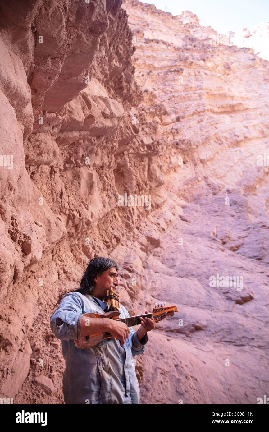Musicien local jouant du charango et de la flûte pan à l'intérieur de l'amphithéâtre de la Quebrada de las Conchas à Salta, au nord-ouest de l'Argentine. Banque D'Images