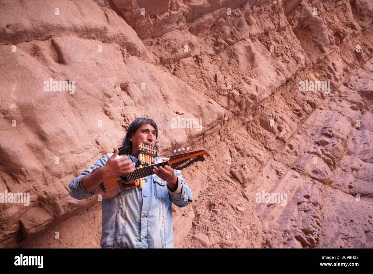 Musicien local jouant du charango et de la flûte pan à l'intérieur de l'amphithéâtre de la Quebrada de las Conchas à Salta, au nord-ouest de l'Argentine. Banque D'Images