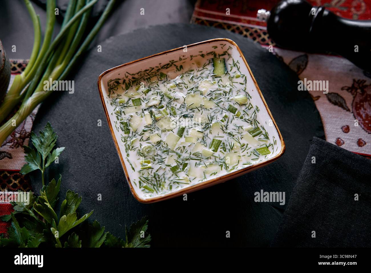 Un délicieux bol de soupe de concombre frais et d'herbes idéal pour les journées d'été parfaitement mélangé avec du yaourt crémeux et des légumes frais Banque D'Images