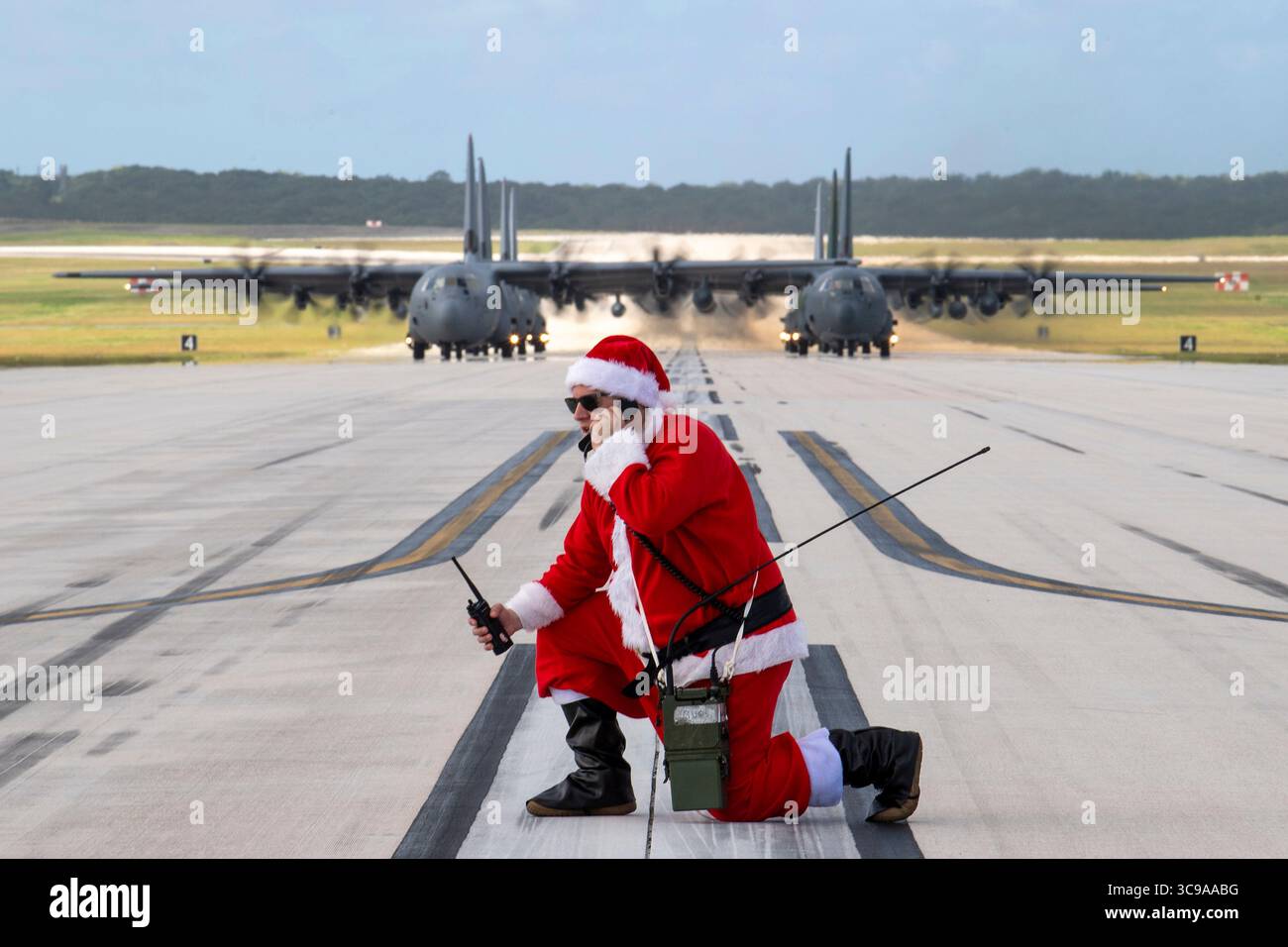 10 décembre 2022, Yigo, Guam, États-Unis : U.S. Air Force Lt. Col. Jeffrey Furnary, vêtu d'un costume de Père Noël, radio les pilotes de fret C-130 alors qu'ils se préparent à décoller pour l'opération Christmas Drop 2022 sur la piste de la base aérienne Andersen, le 10 décembre 2022 à Yigo, Guam. Sept avions C-130 de l'US Air Force, de la Royal Australian Air Force, de la Japan Air Self-Defense Force, de la Republic of Korea Air Force et de la Royal New Zealand Air Force ont livré 71 000 livres de nourriture, de cadeaux et de fournitures pour aider les communautés insulaires éloignées du Pacifique Sud. (Crédit image : © Yasuo Osakabe/US Airforce/Plan Banque D'Images