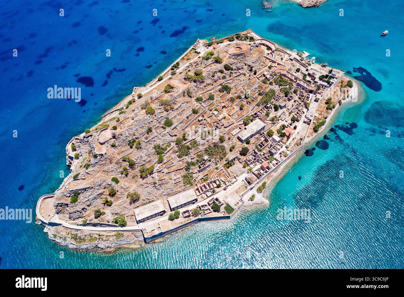 Vue aérienne de l'île de Spinalonga en Crète, Grèce, montrant les ruines historiques, les murs de pierre et les eaux turquoises de la mer Égée. Banque D'Images