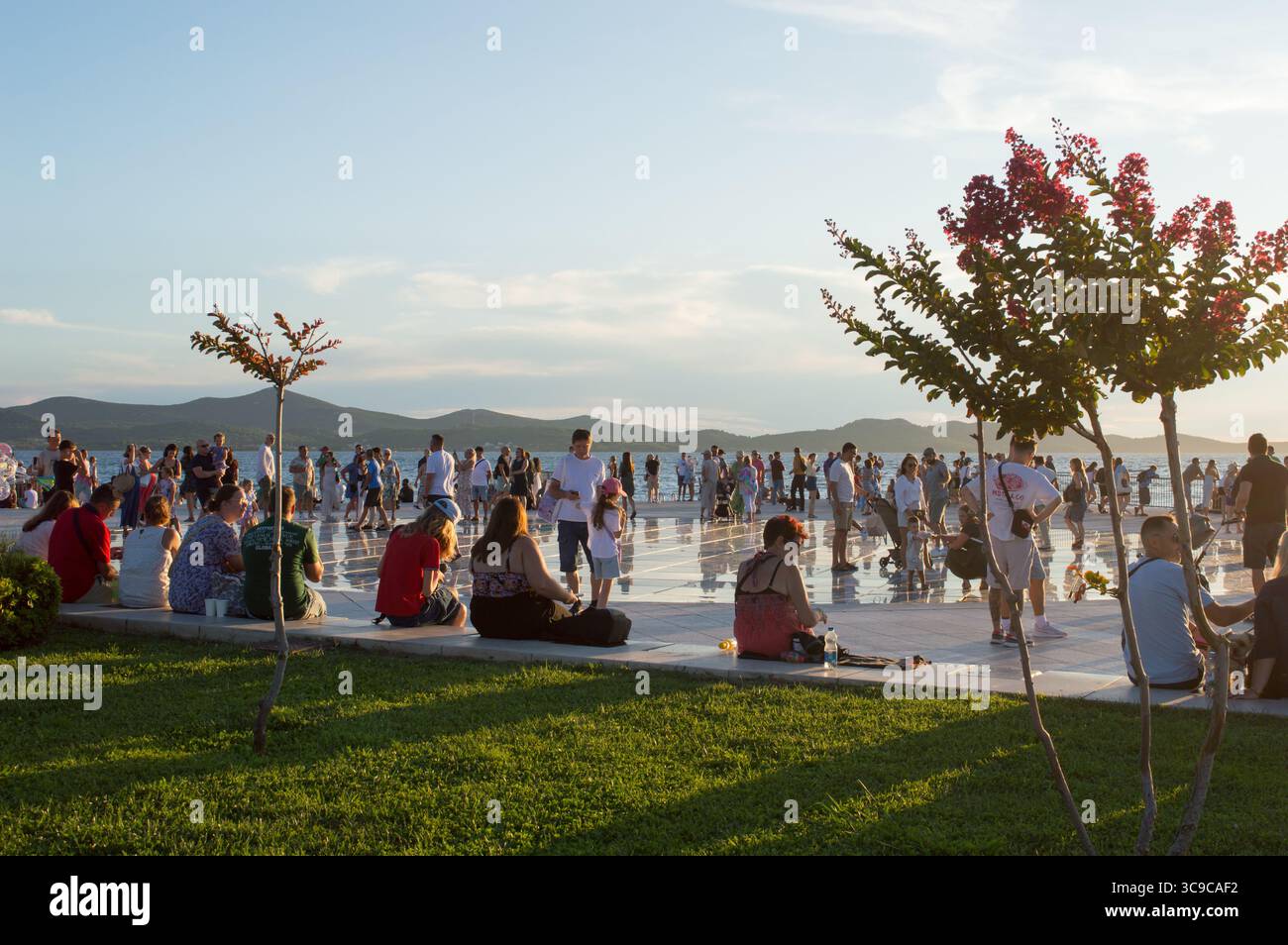Zadar, Croatie - 27 juillet 2025 : les touristes visitent et apprécient l'attraction célèbre, salutation au soleil et l'installation d'orgue de mer, instrument de musique qui pl Banque D'Images