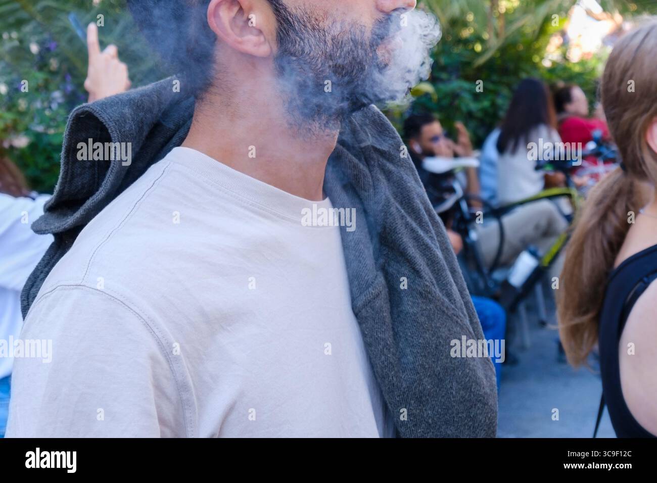 Gros plan de la partie inférieure du visage de l'homme fumeur dans le centre de la ville européenne, le visage est méconnaissable, photo dépersonnalisée Banque D'Images
