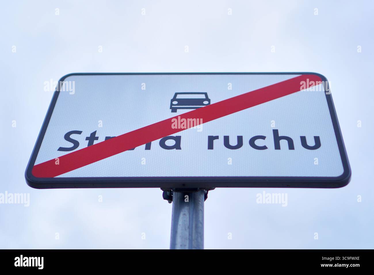 Panneau de signalisation blanc en langue polonaise indiquant la fin d'une zone de circulation des véhicules. Banque D'Images