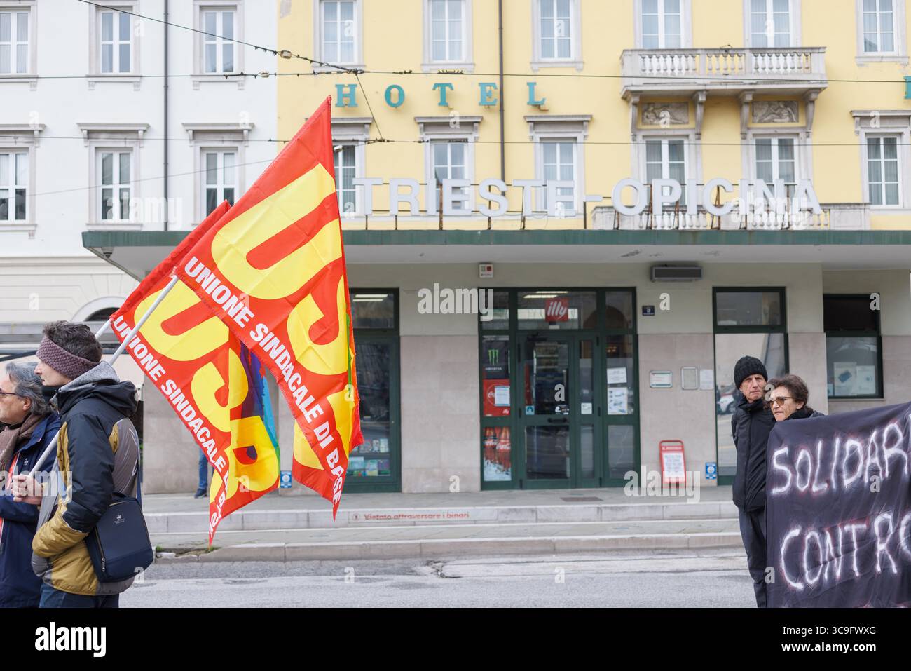 Trieste, Italie – 8 février 2025 : un groupe de militants italiens avec USB, syndicat de base, drapeaux lors d'une mobilisation syndicale soutenant le droit des travailleurs Banque D'Images Trieste, Italie – 8 février 2025 : un groupe de militants italiens avec USB, syndicat de base, drapeaux lors d'une mobilisation syndicale soutenant le droit des travailleurs Banque D'Images