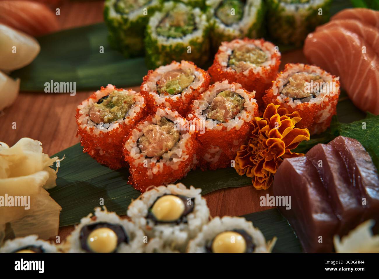 Un assortiment vibrant de Sushi Rolls avec des ingrédients colorés et des fruits de mer frais sur un plateau en bois avec des garnitures Banque D'Images
